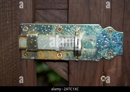 a slide latch on a wooden door photographed. Stock Photo