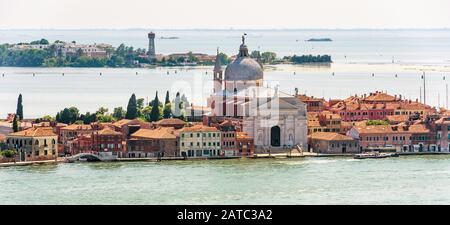 Venice city in the sea taken from above, Italy. Panorama of marine Venice with old houses and church. Aerial view of islands of Venice in summer. City Stock Photo