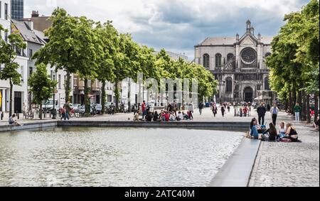 Brussels Old Town, Brussels Capital Region, Belgium - 06 09 2017: People sitting around the fountain at the Saint Catherine marketplace in summer Stock Photo