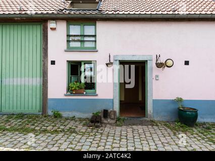 Uccle, Brussels / Belgium - 06 14 2019: Vintage  facade of a brick stone farmers house with a green window in the Fond' Roy park Stock Photo
