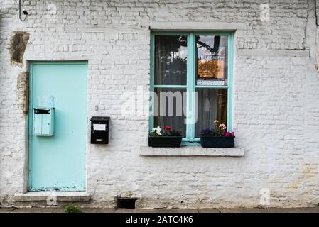Uccle, Brussels / Belgium - 06 14 2019: Vintage  facade of a brick stone farmers house with a green window in the Fond' Roy park Stock Photo