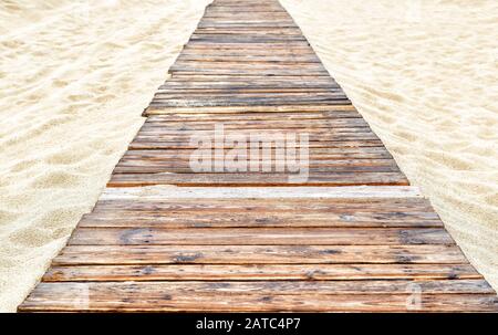 Panorama of deserted sandy beach with a wooden pathway in Anapa, Russia. Tourist track with an old decking to sea. Footpath is paved with vintage boar Stock Photo