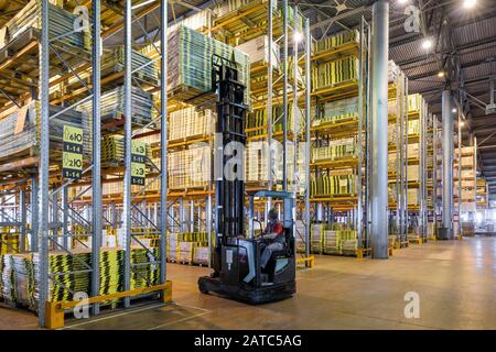 Moscow - August 1, 2017: The worker loads goods in a large warehouse. Moscow is a modern city with well-developed logistics infrastructure. Stock Photo