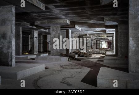 Concrete construction of underground level of building. Panorama inside the modern construction site in dark. Contemporary structure under constructio Stock Photo