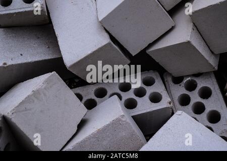 Stack of white hollow facing bricks with holes foreground closeup, white bricks stack Stock Photo