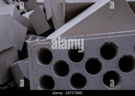 Stack of white hollow facing bricks with holes foreground closeup, white bricks stack Stock Photo