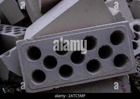 Stack of white hollow facing bricks with holes foreground closeup, white bricks stack Stock Photo