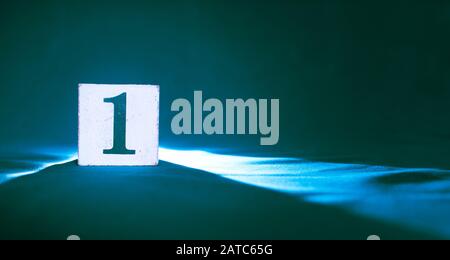 Block with number 1, one, on a dark blue background Stock Photo