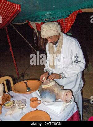 Chef preparing food in the camp restaurant from a traditional clay pot. Stewed in charcoal. Stock Photo