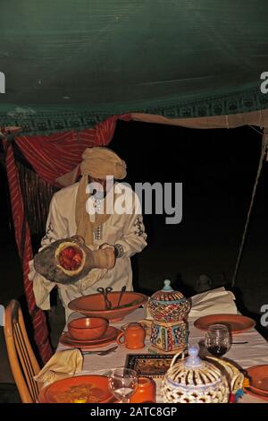Chef serving food in the camp restaurant from a traditional clay pot. Stewed in charcoal. Stock Photo