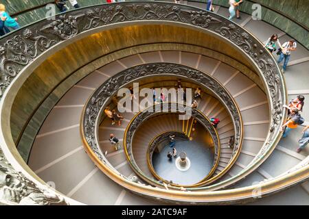 VATICAN - MAY 14, 2014: Tourists walk down the famous spiral staircase in Vatican Museum. Stock Photo