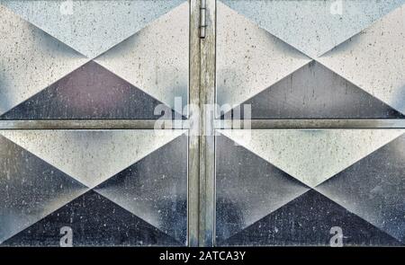 Section of unpainted, panelled steel garage door showing some weathering Stock Photo