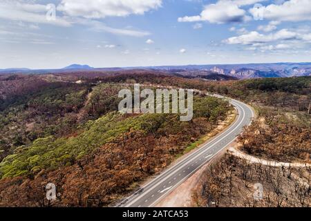 Bells line of road in BLue Mountains of Australia going through devastated areas of gum-tree forests after heavy bushfires with burnt woods. Stock Photo