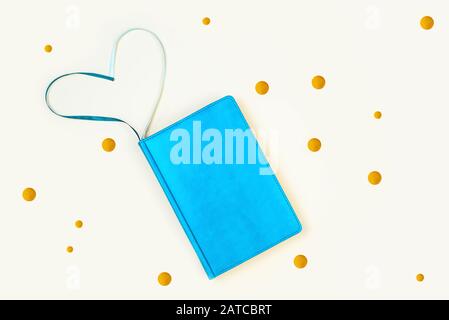 Blue diary and golden rounds. On a light background. Heart-shaped bookmarks Stock Photo