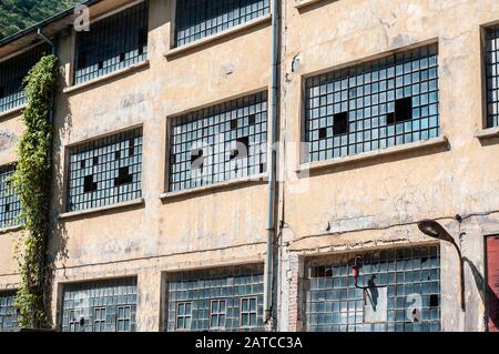 Old obsolete industrial building facade with broken windows Stock Photo
