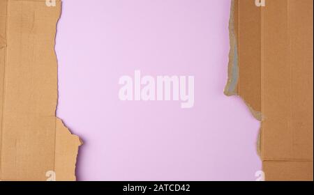 torn edges of corrugated cardboard paper with purple background, abstract backdrop template Stock Photo