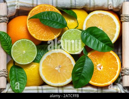 Sliced citrus in a basket. Flat lay. Juicy ripe slices of orange, lemon and lime. Fruit mix, top view. Food background. Stock Photo