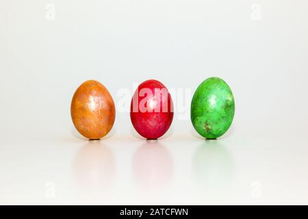 Yellow, red and green egg on white background Stock Photo
