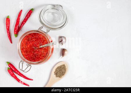 Hot chili pepper sauce paste harissa. Adjika on a white background. Traditional Tunisia, Georgian and Arabic cuisine. Homemade rose harissa Stock Photo