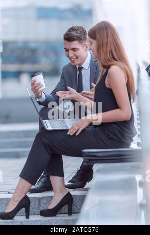 corporate couple discussing something about sitting on near office building Stock Photo
