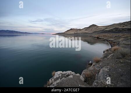 Rock formations and reflections of Pyramid Lake, Nevada on clear tranquil winter afternoon. Stock Photo