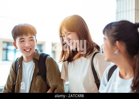 Group of happy students walking along the corridor at college Stock Photo