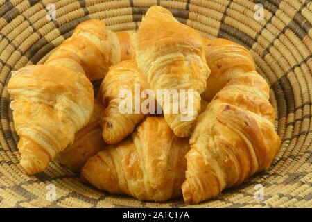 Close up of bunch of breakfast croissant pastries in woven basket Stock Photo
