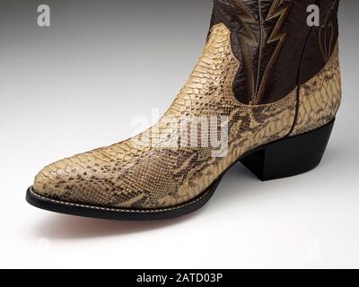 Cowboy boot made from the skin of a reticulated python (Malayopython reticulatus). The reticulated python is native to Asia. They are heavily exploite Stock Photo