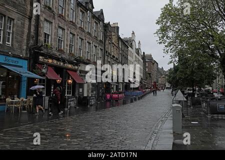 Edinburgh, Scotland / UK - June 12, 2019: Pubs and shops along the Grassmarket district are shown during a rainy day. For editorial uses only. Stock Photo
