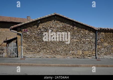 A dry stone wall country farmhouse, or shed in Mairie de Moiré on the road through town, timber frame gate. Vernacular architecture in France. Stock Photo