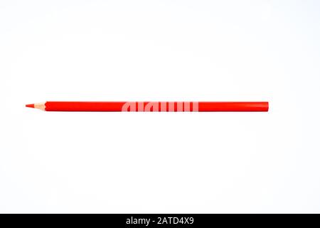 A sharpened red colored pencil crayon is isolated on a white background Stock Photo