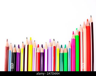 A stack of different colored pencil crayons arranged on a white background Stock Photo