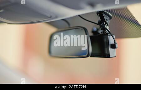 Black dashcam video recorder behind mirror close up view Stock Photo