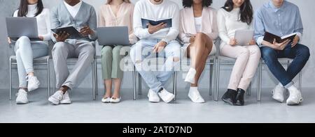 Cropped photo of diverse people sitting in line Stock Photo