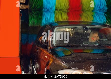 Woman in auto on automatic car wash station Stock Photo