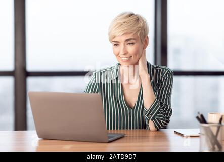 Successful Middle-Aged Businesswoman Using Laptop Sitting At Workplace Indoor Stock Photo