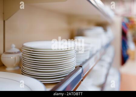 White plates on the shelf closeup, houseware store Stock Photo