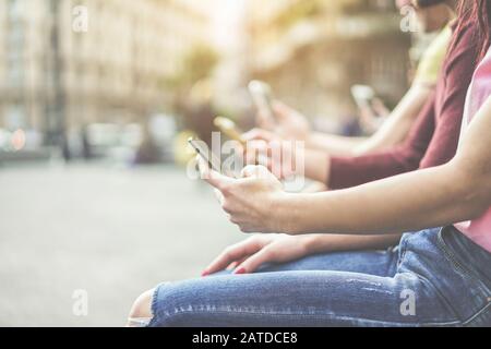 Group of teenagers friends watching mobile phones in city - Young people addiction to technology trends - Alienation moment for new generation problem Stock Photo