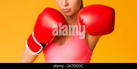 Unrecognizable Fit Woman In Red Boxing Gloves Posing Over Yellow Background Stock Photo