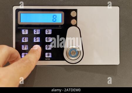 Closeup finger touching keypad of digital safe Stock Photo