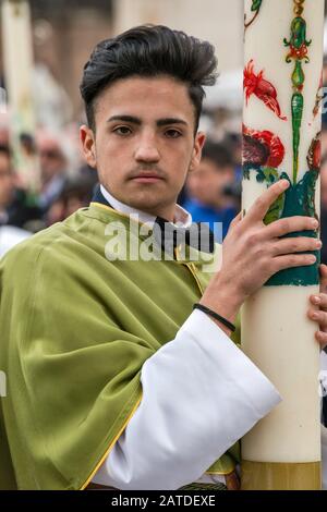 Young man, member of Confraternity of Madonna di Loreto, holding huge candle at Madonna che Scappa celebration on Easter Sunday in Sulmona, Italy Stock Photo