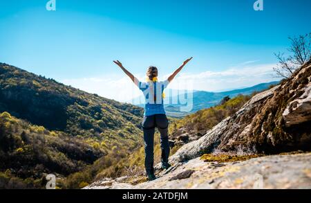 Hiking woman enjoying the freedom of a mountainous landscape Stock Photo