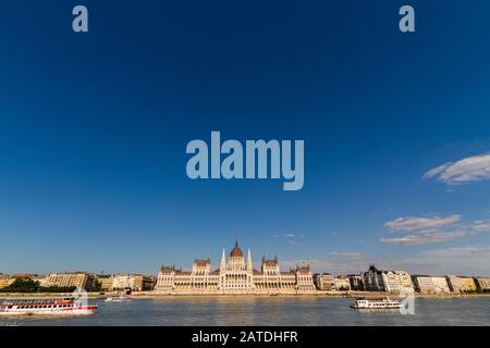 The Hungarian Parliament Building from across the river Danube with ferry boats, Hungary, Budapest, copyspace at top. Stock Photo