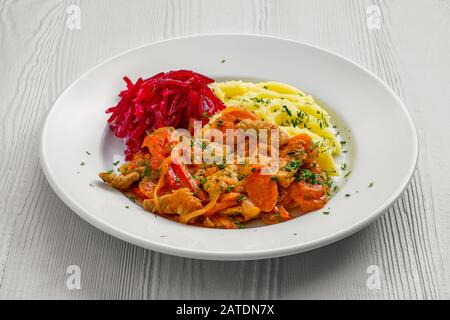 Plate with beef goulash, mashed potato and beetroot salad Stock Photo