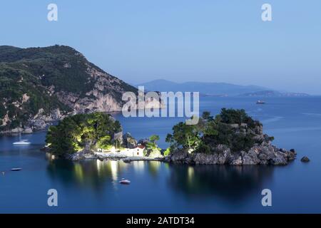 Viewed here is Panagia Island in low light. Set about 100 metres or so from Parga Town shoreline people can either swim or row to the small church th. Stock Photo