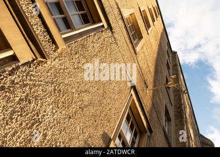Side of yellow pebbledashed tall building showing the texture, in Edinburgh, Scotland Stock Photo