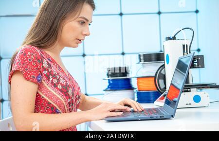 Young female designer works with a home 3D printer Stock Photo