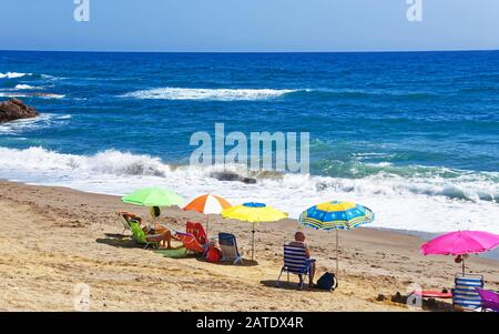 People sunbathing on beach at Mediterranean Sea in Marbella Stock Photo