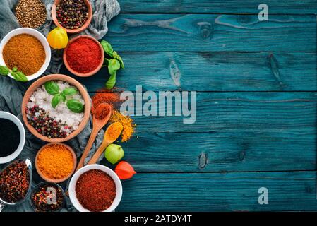 Spices and herbs on a blue wooden table. Basil, pepper, saffron, spices. Indian traditional cuisine. Top view. Free copy space. Stock Photo