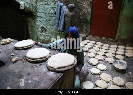 Manfalut, Egypt. 29th Jan, 2020. A picture provided on 02 February 2020 shows a woman baking Sun Bread, known in local dialect as 'Eish Shamsi', a thick sourdough bread made from wheat flour that has a popularity in the provinces of Upper Egypt, at the 'Al Hawatkah' village, located in the perimeter of the city of Manfalut. Credit: Lobna Tarek/dpa/Alamy Live News Stock Photo